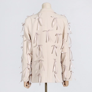 Close-up of beige blazer back featuring detailed silk bow embellishments and stitching