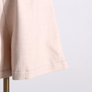 Gros plan détaillé sur la texture tissée et les coutures soignées du revers de la veste rose