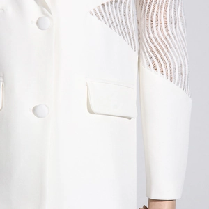 Dettaglio blazer bianco con maniche a righe traforate e raffinati bottoni rotondi