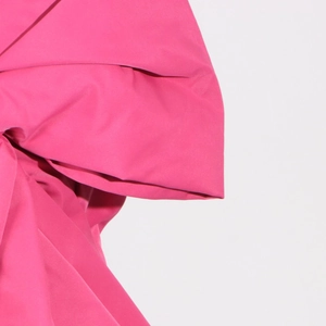 Detail shot of a bright fuchsia bow decoration showing premium woven fabric and texture