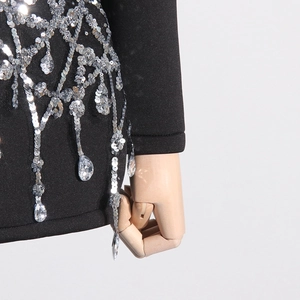 Detail of black dress with sequin chandelier patterns and sparkling crystal pendants