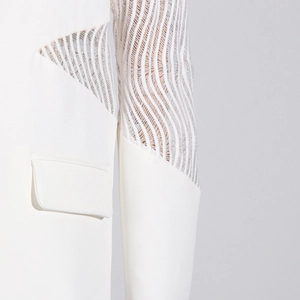 Dettaglio del blazer bianco con cuciture in pizzo a onde e maniche in mesh trasparente