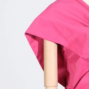 Detail of elegant dark pink satin blouse with draped pleats and bow on wooden mannequin