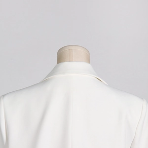 Dettaglio della spalla del blazer bianco con pizzo e scollatura a V traforata