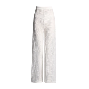 Détail d'un pantalon blanc à taille haute et jambe large avec texture en maille ondulée