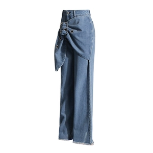 Detail of deconstructed high-waisted denim jeans with silver ring buckle and eyelets