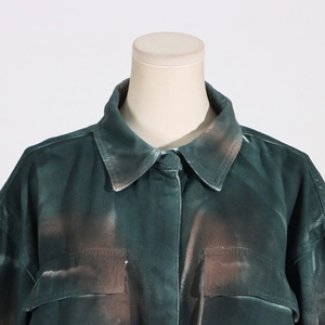 Detailed macro view of retro green denim jacket with acid wash texture and flap pockets