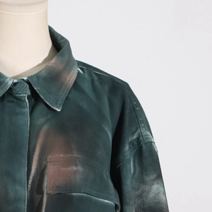 Detail of dark green cotton jacket featuring classic collar and functional chest pocket