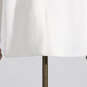 Dettaglio dell'orlo liscio e delle cuciture precise su un blazer bianco in pizzo