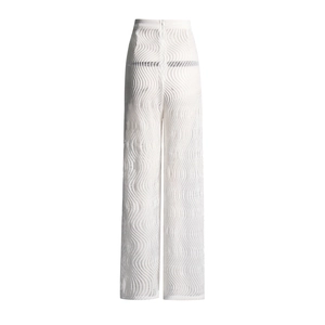 Détail macro du pantalon blanc en maille transparente avec texture ondulée chic