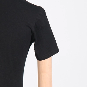 Close-up of the smooth black cotton fabric and precise stitching on the shoulder and sleeve