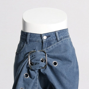 Detail of high waisted denim pants featuring large square metal buckle and eyelet belt design
