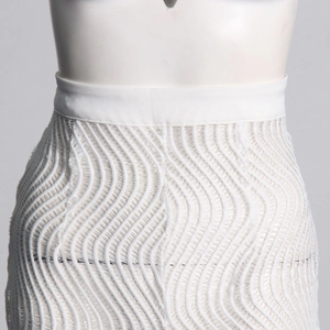Détail d'une jupe blanche taille haute avec une maille texturée à motifs de vagues