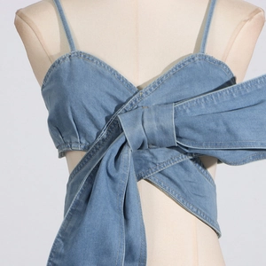 Detailansicht des Denim-Tube-Tops mit großer Schleife und gelben Kontrastnähten aus Jeans