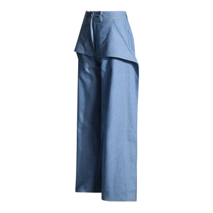 Détail du jean bleu taille haute avec pli asymétrique et coutures contrastées