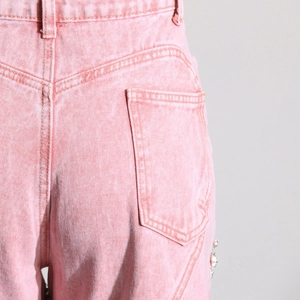 Detail der rosa Jeanshose mit Strass-Seitenakzenten und hoch taillierter Taschennaht