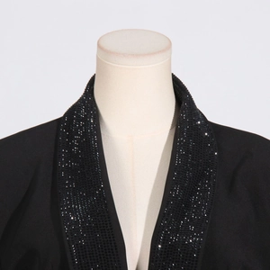 Dettaglio del risvolto con perline di lusso e paillettes nere sul blazer elegante