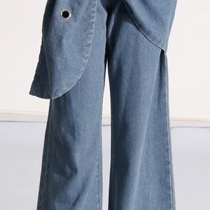 Detail of light blue denim wide leg jeans showing metal eyelet and fabric texture