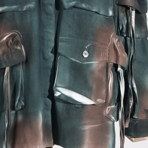Detail of cargo jacket with camo dye, multiple utility pockets and tactical straps