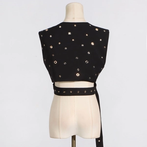 Detail of backless black vest with metal eyelets and wrap-around waist strap