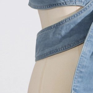 Detailansicht eines blauen Denim-Korsetts mit Kreuzwickel-Design und Kontrastnähten
