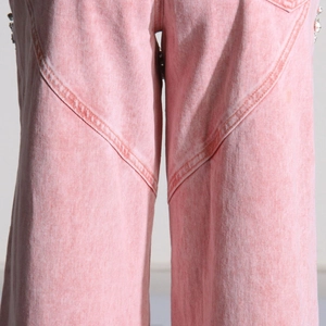 Detail der rosa Jeanshose mit geschwungenen Nähten und dezenten Strassverzierungen an der Seite