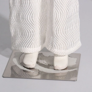 Détail du pantalon blanc à maille ondulée avec texture transparente et extensible