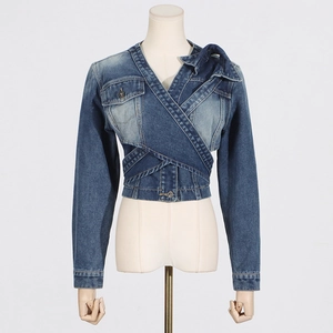 Detail view of denim jacket showing asymmetric crossover front and button waist straps