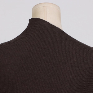Detail view of the ribbed knit texture and mock neck collar on this slim brown dress