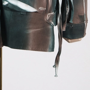 Detailed macro view of the camouflage denim jacket texture with drawstring design