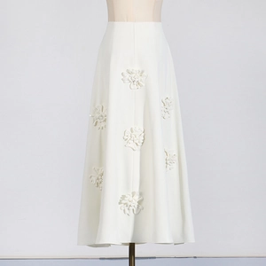 Detailed macro view of cream 3D floral appliques on the high-waisted A-line skirt