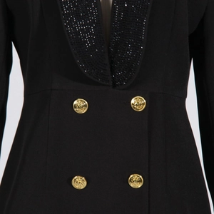 Dettaglio del blazer nero con revers di paillettes e bottoni dorati in rilievo