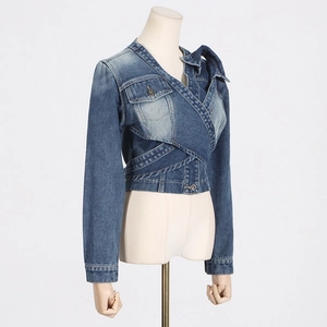 Detail of blue cropped denim jacket featuring asymmetric wrap design and metal buttons