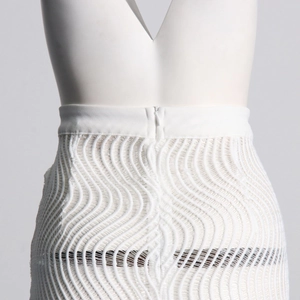 Détail du pantalon en maille blanche à taille haute avec texture ondulée et zip