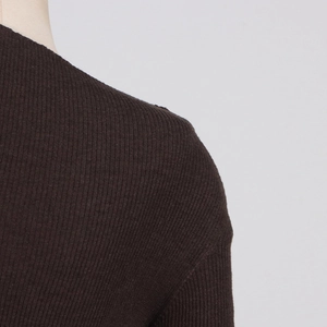 Detailed macro shot of ribbed knit texture and shoulder seam on dark brown dress
