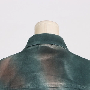 Detail of cargo jacket collar showing olive green tie-dye denim and twill texture