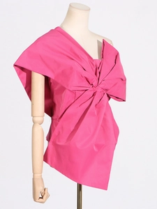Elegant bright pink asymmetric neck blouse with large bow decoration on white background