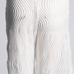 Détail du pantalon blanc transparent avec tissu texturé en 3D et finition plissée