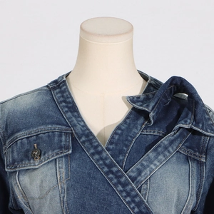 Detail of cross-over V-neck denim jacket with metallic button and washed texture