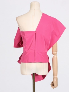 Pink one-shoulder asymmetrical top with a decorative bow and puff sleeve on a mannequin