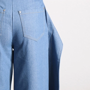 Vue détaillée du jean taille haute avec rivets de poche et coutures latérales superposées