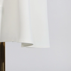 Detailed close-up of white A-line skirt hem showing fine stitching and draped fabric