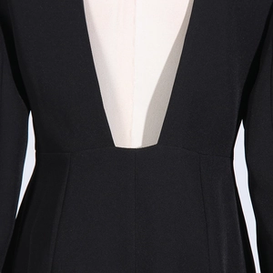 Dettaglio dello scollo a V profondo con perline e cuciture a contrasto su blazer nero