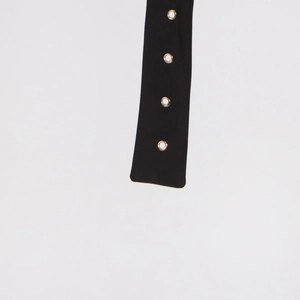 Detailed macro view of black fabric strap with four metallic circular eyelets for vests