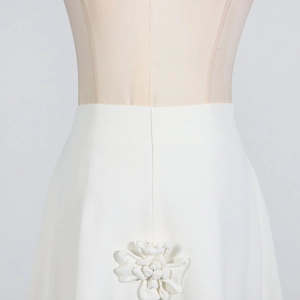 Detailed view of the 3D flower applique on a white high-waist A-line skirt
