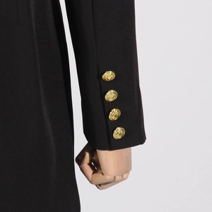 Dettaglio della manica di un blazer in twill nero con quattro bottoni in metallo dorato