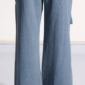 Detail view of light blue wide-leg denim jeans showing the straight-cut hem and washed texture