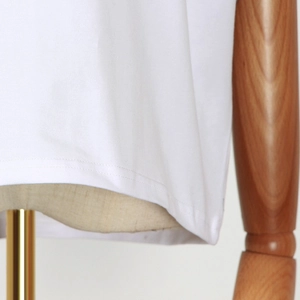 Detail view of the double-stitched hem on a minimalist white cotton summer sleeveless top