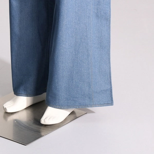 Détail de l'ourlet du jean large bleu clair montrant les surpiqûres jaunes de qualité