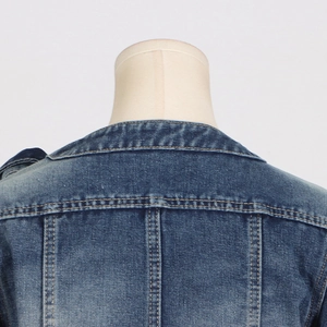Close-up of denim jacket back collar with yellow stitching and faded blue wash detail